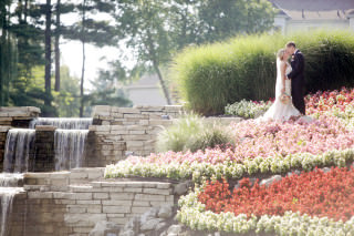 The happily married couple share a kiss by the waterfall at the lakes golf and country club in westerville.